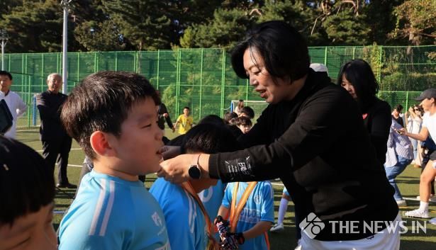 과천시 문원동 어린이 축구 페스티벌에서 신계용 과천시장이 아이들에게 메달을 걸어주고 있다